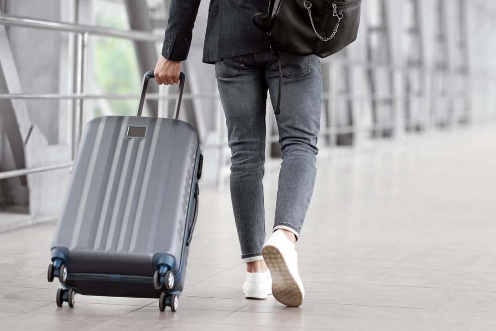 Man Walking With Suitcase In Airport Terminal