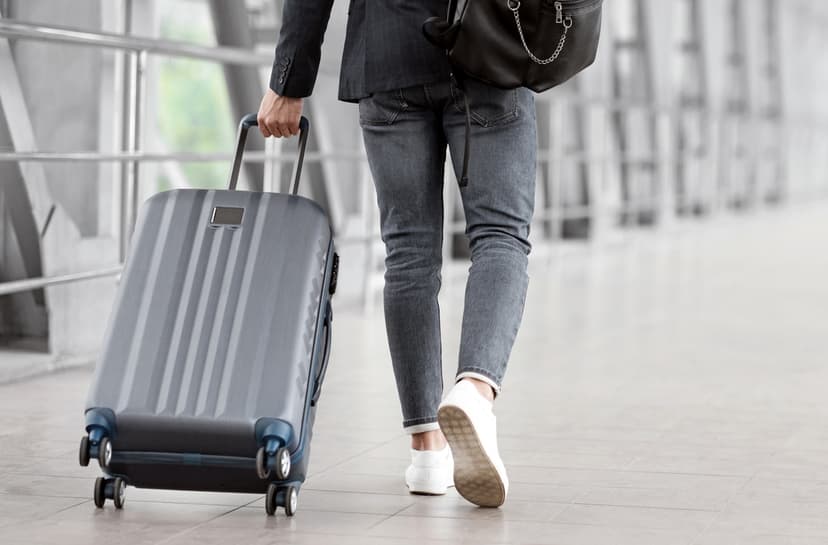 Man Walking With Suitcase In Airport Terminal
